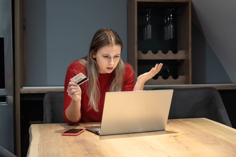 frustrated woman holding bank credit card annoyed that she has reached her account limit and has no more money
